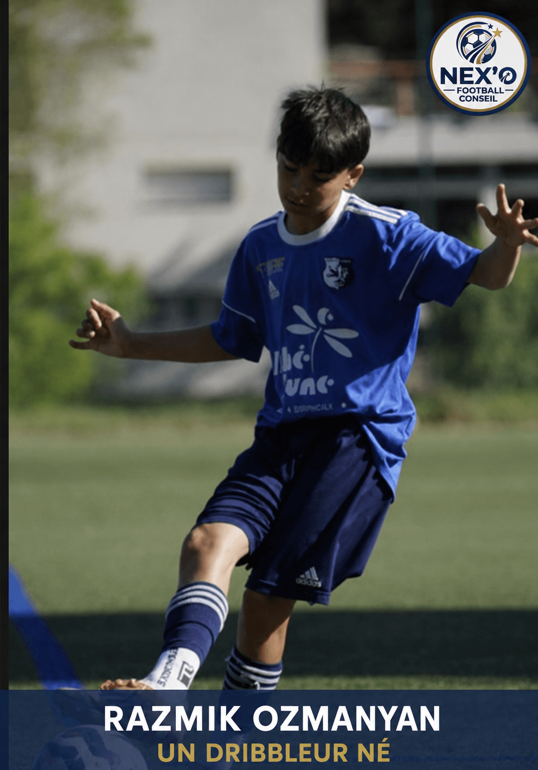 Razmik Ozmanyan, jeune footballeur en maillot bleu, dribble un ballon sur un terrain extérieur.