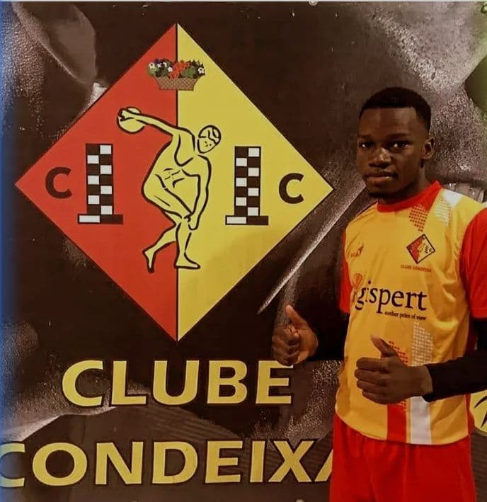 Un jeune athlète en maillot jaune et rouge pose devant le logo du Clube Condeixa.
